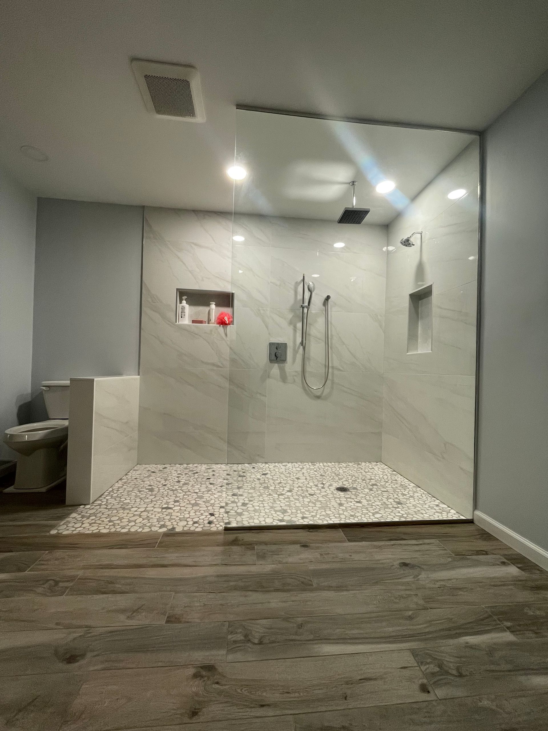 A bathroom with a walk in shower and a toilet.