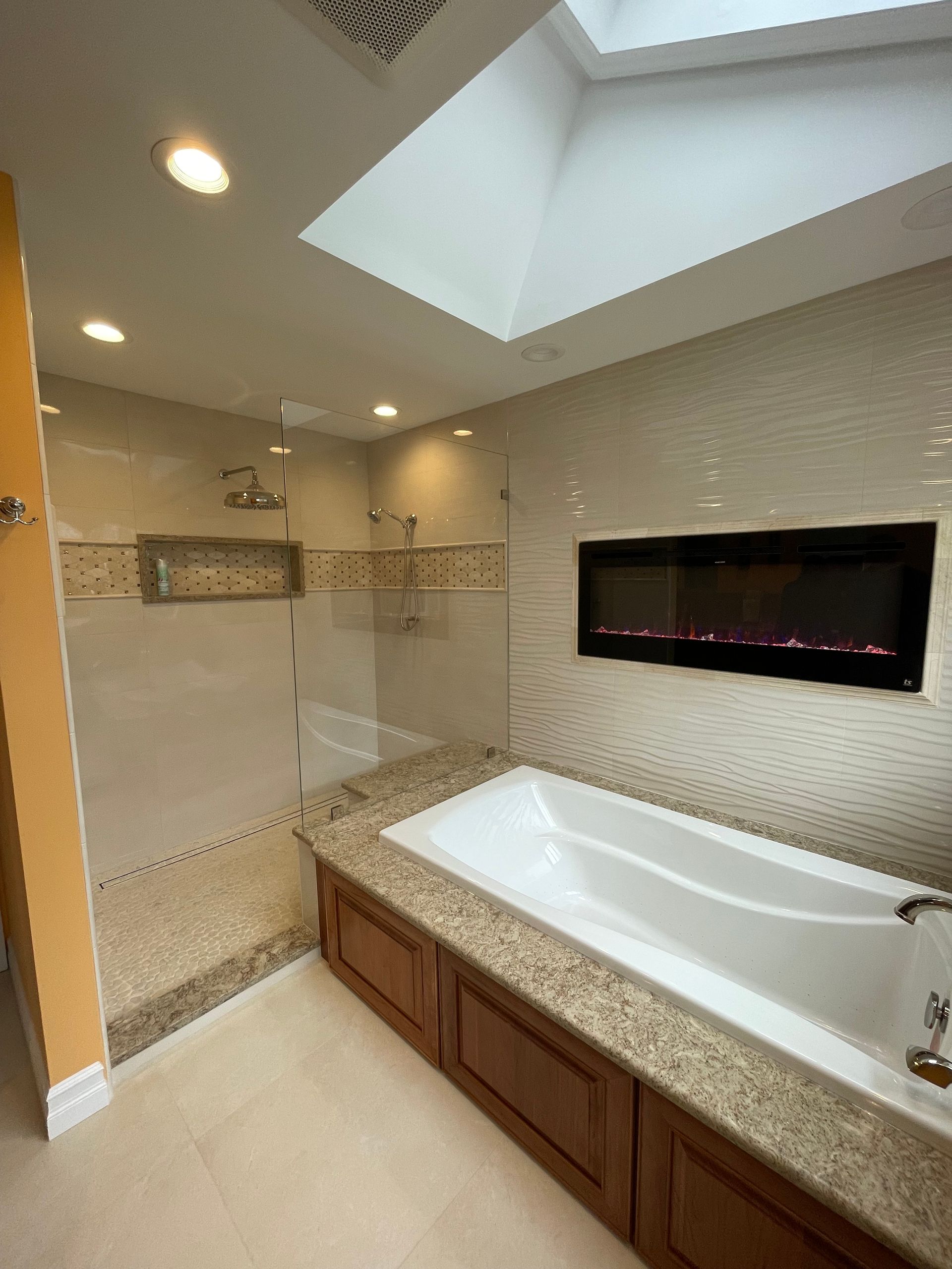 A bathroom with a tub , shower , and fireplace.