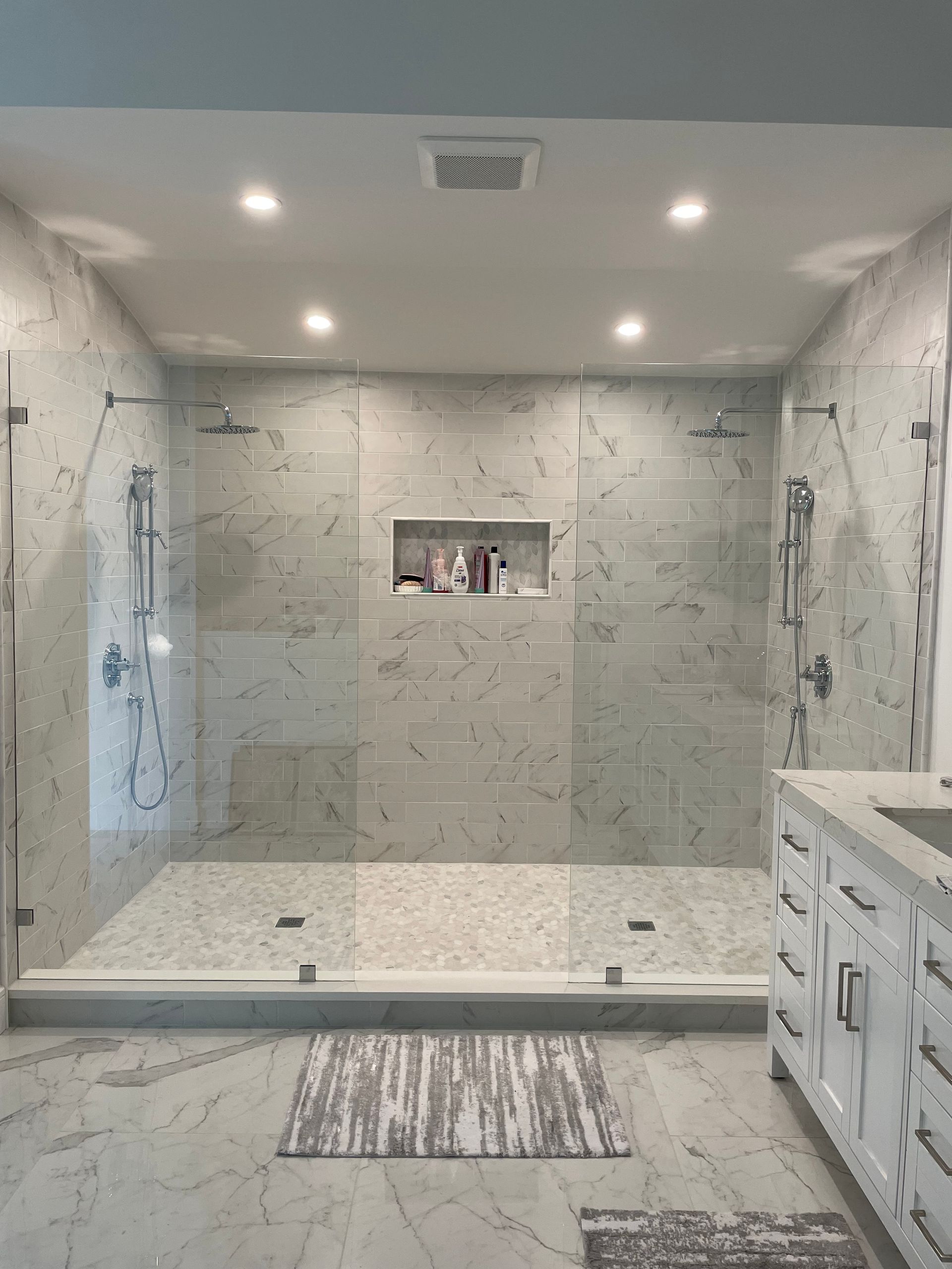 A bathroom with a walk in shower and a sink.