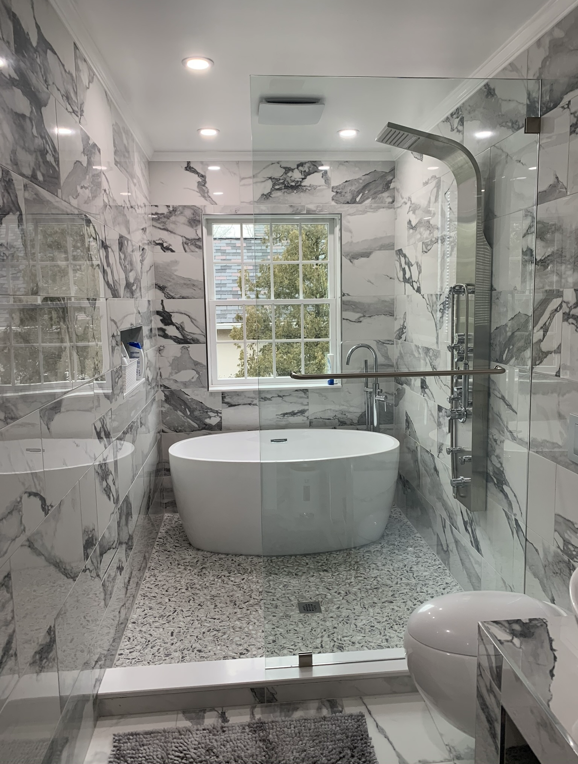 A bathroom with a tub , sink , shower and mirror.