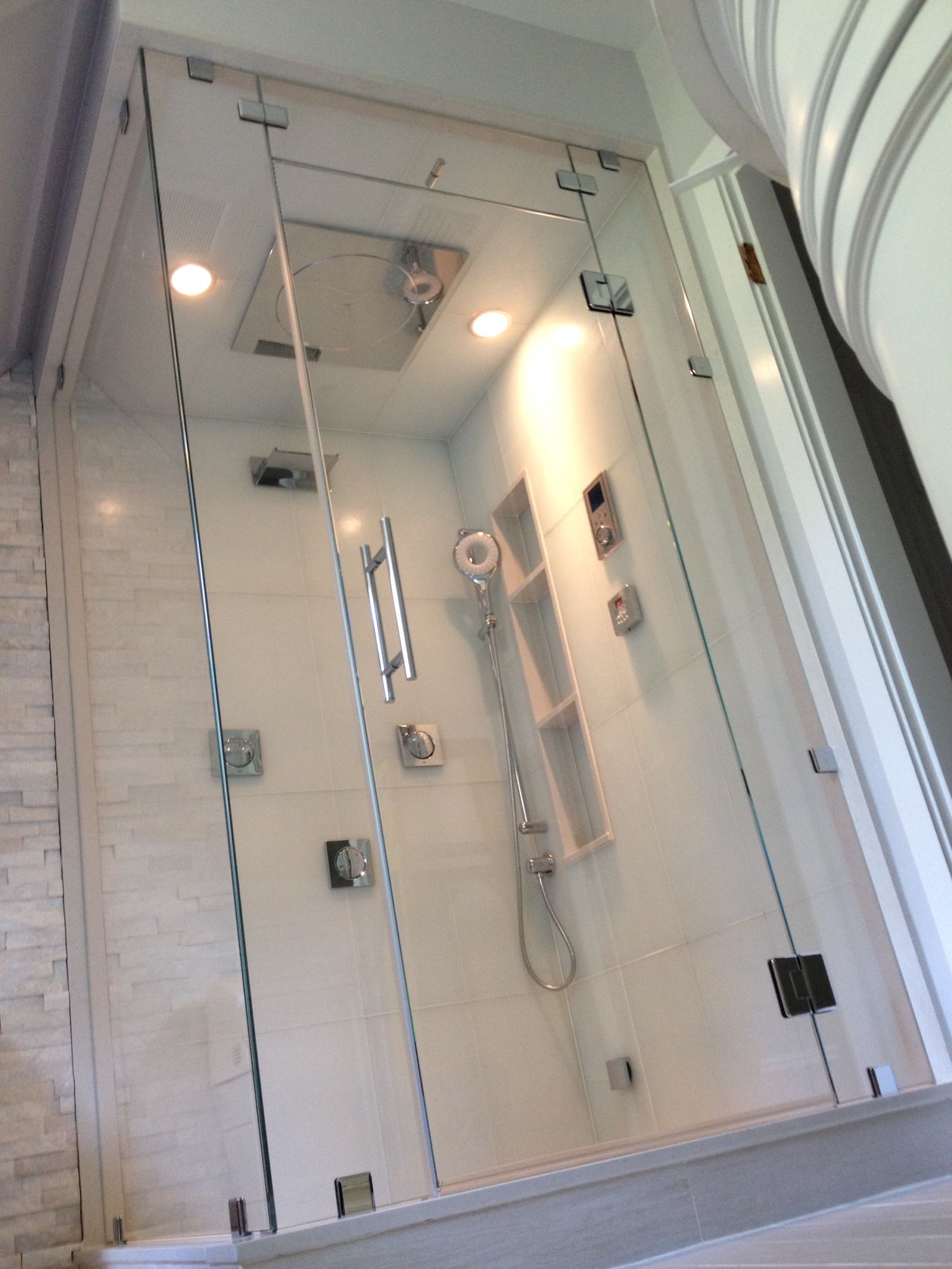 A shower stall with a glass door and a shower head