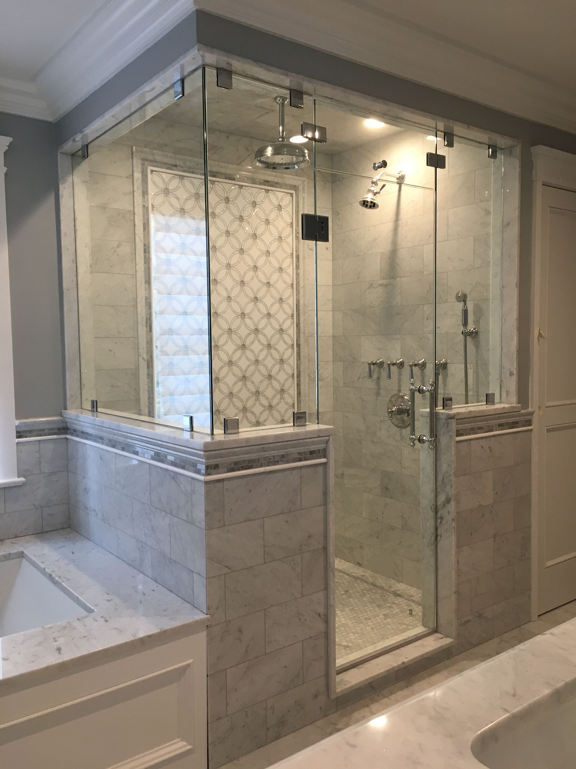 A bathroom with a walk in shower and a bathtub.