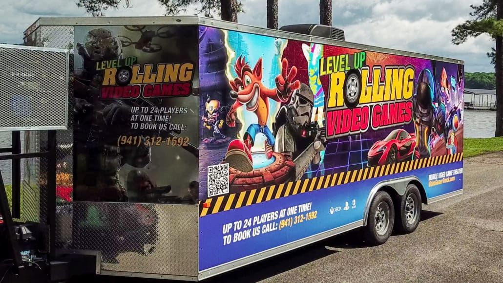 Game trailer with colorful Crash Bandicoot art, parked outdoors. 