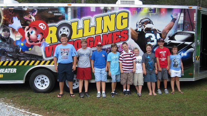Group of kids standing in front of a trailer with 