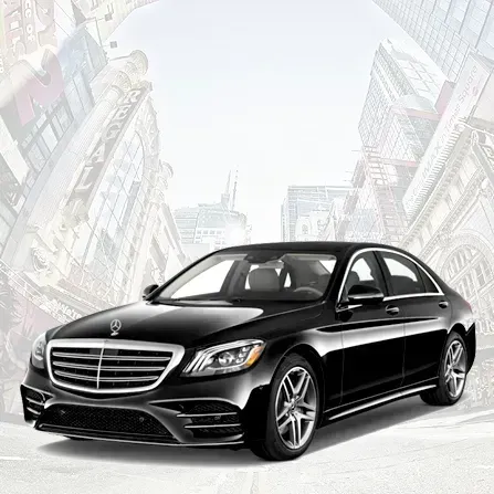Black luxury sedan on a city street, front view with tall buildings in the background