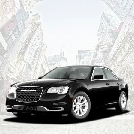 Black sedan car on a city street with a light gray urban backdrop