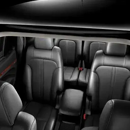 Black leather car seats in a spacious SUV interior with three rows visible.