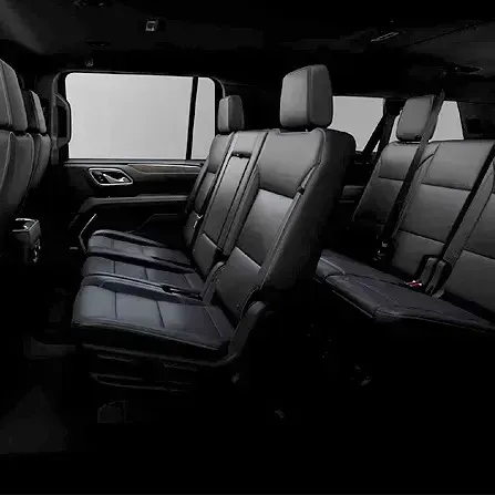 Black leather seats inside a spacious vehicle cabin, viewed from the side.