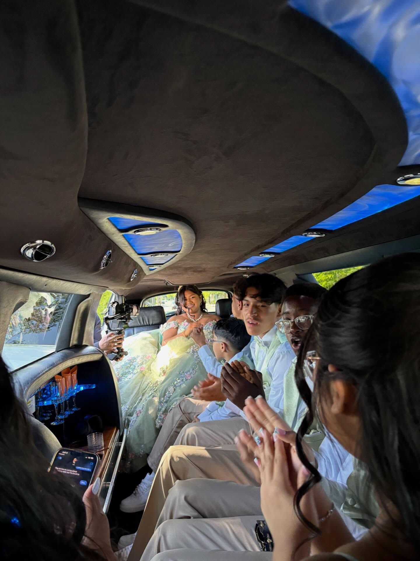 People clapping inside a decorated van with blue interior lights and sunroof windows