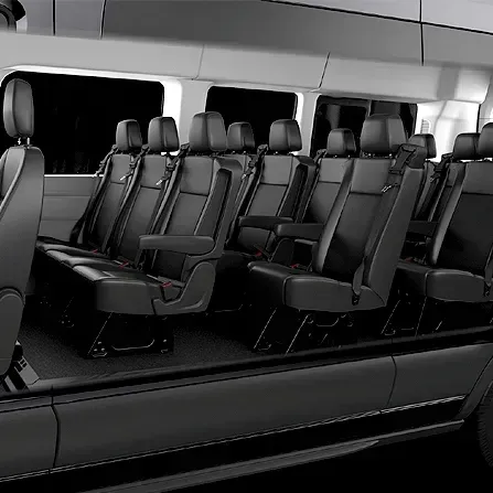 Empty black leather passenger seats inside a modern van or shuttle bus interior