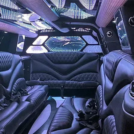 Purple-lit luxury van interior with black leather seats and futuristic ceiling lights
