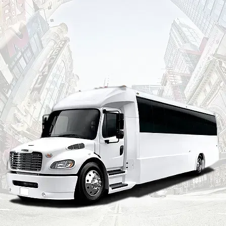 White luxury tour bus on a city street, angled front view, with a blurred urban background