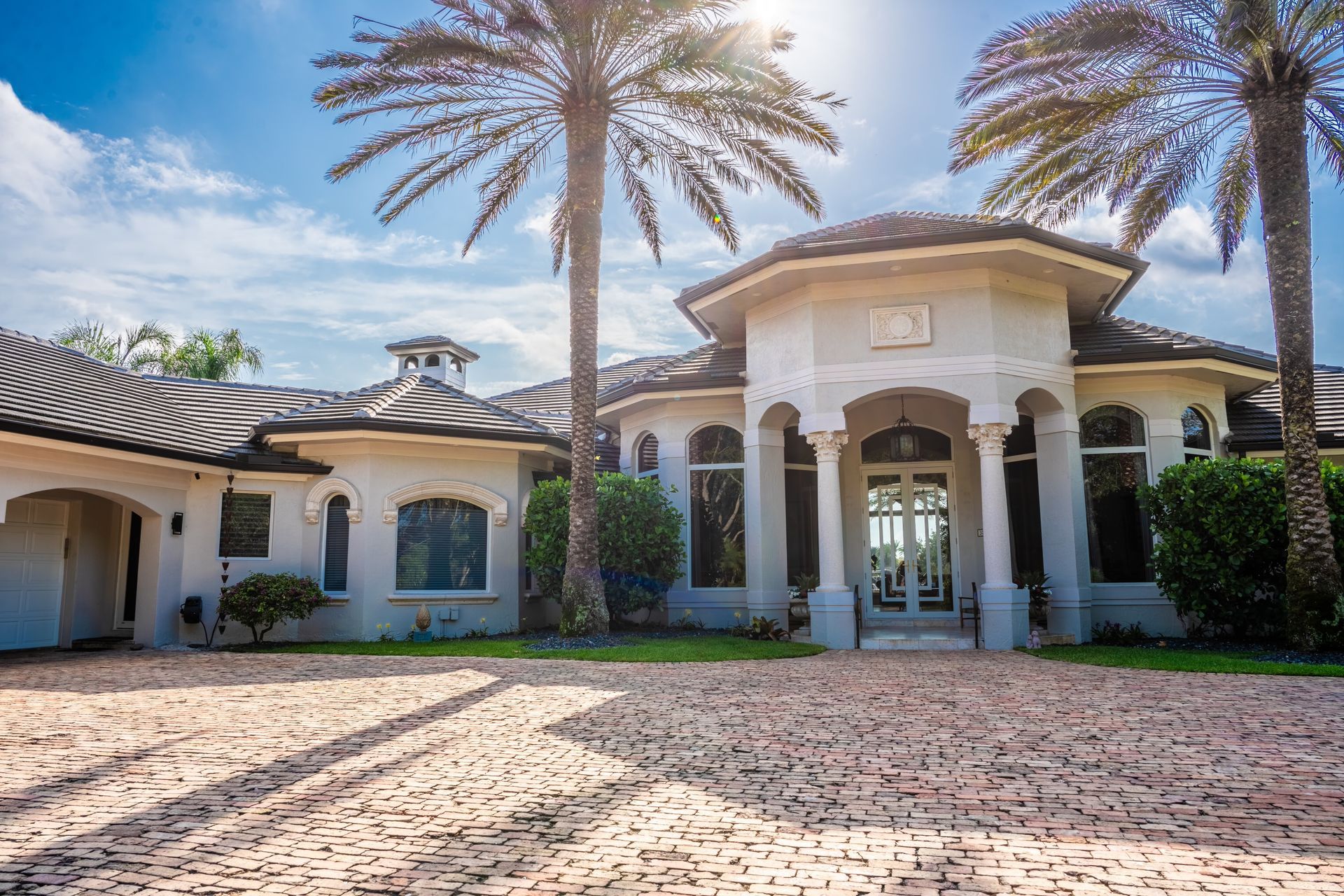 A large white house with palm trees in front of it.