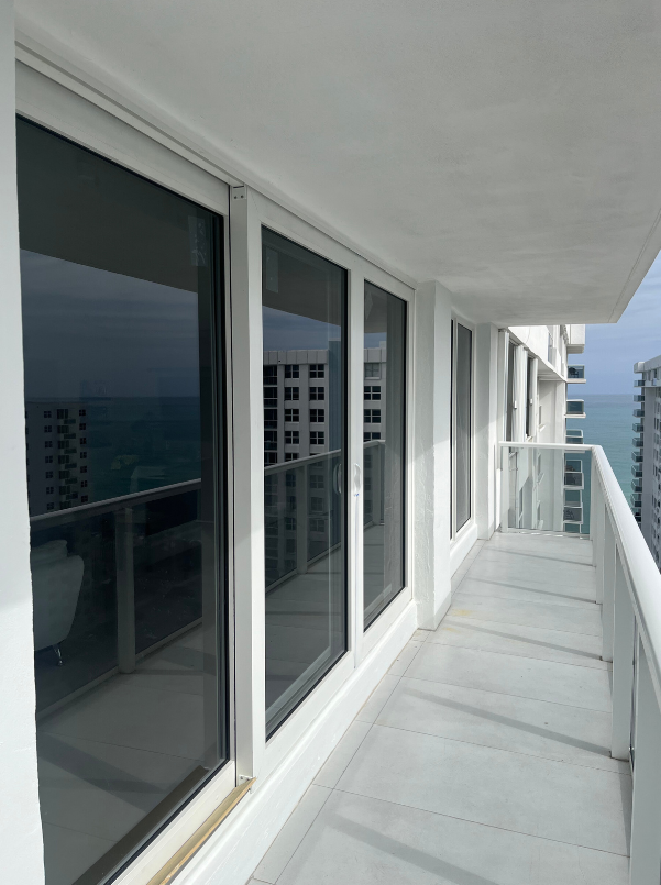 A balcony with a view of the ocean and buildings