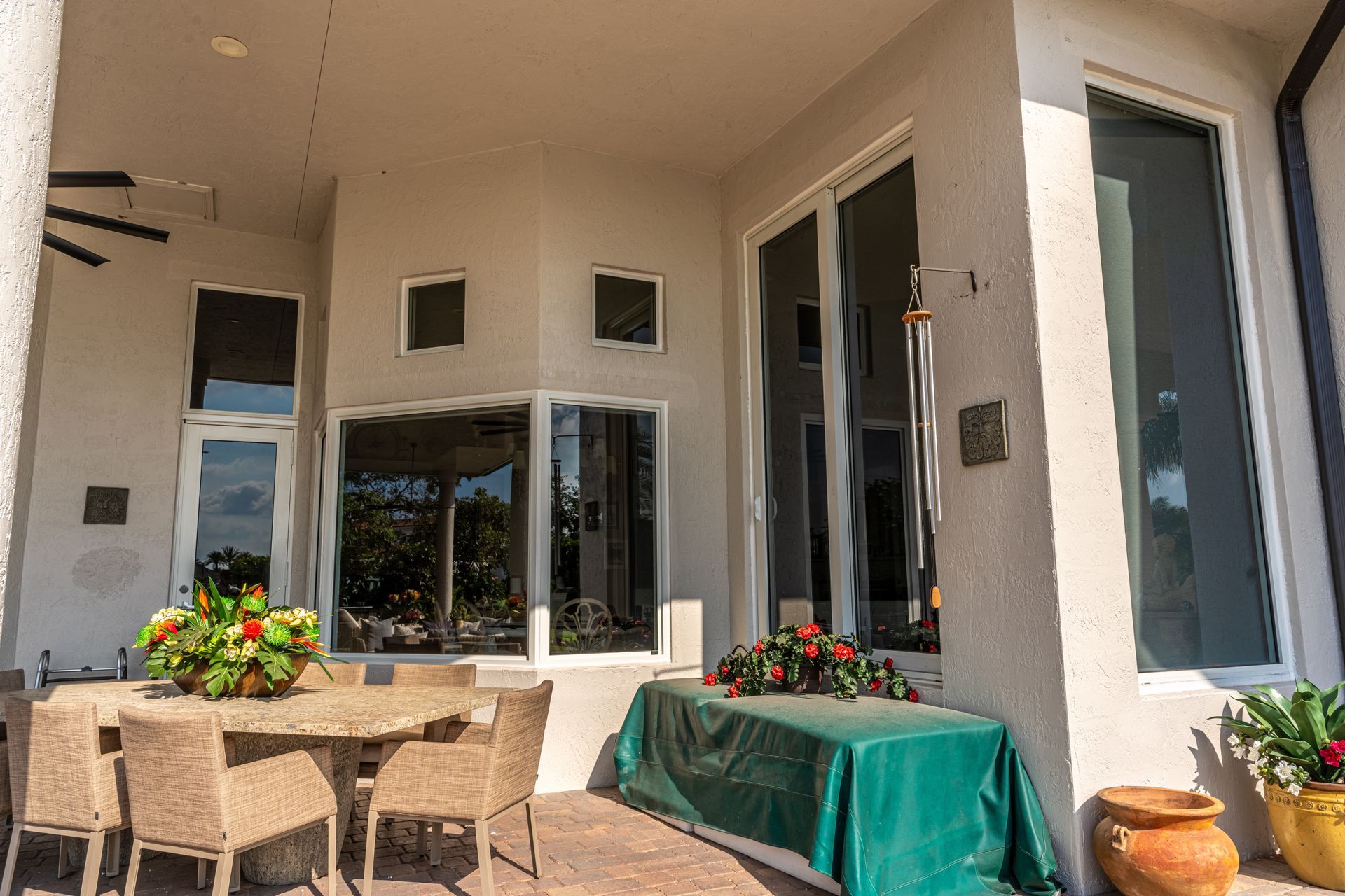 A patio with a table and chairs and a green table cloth.