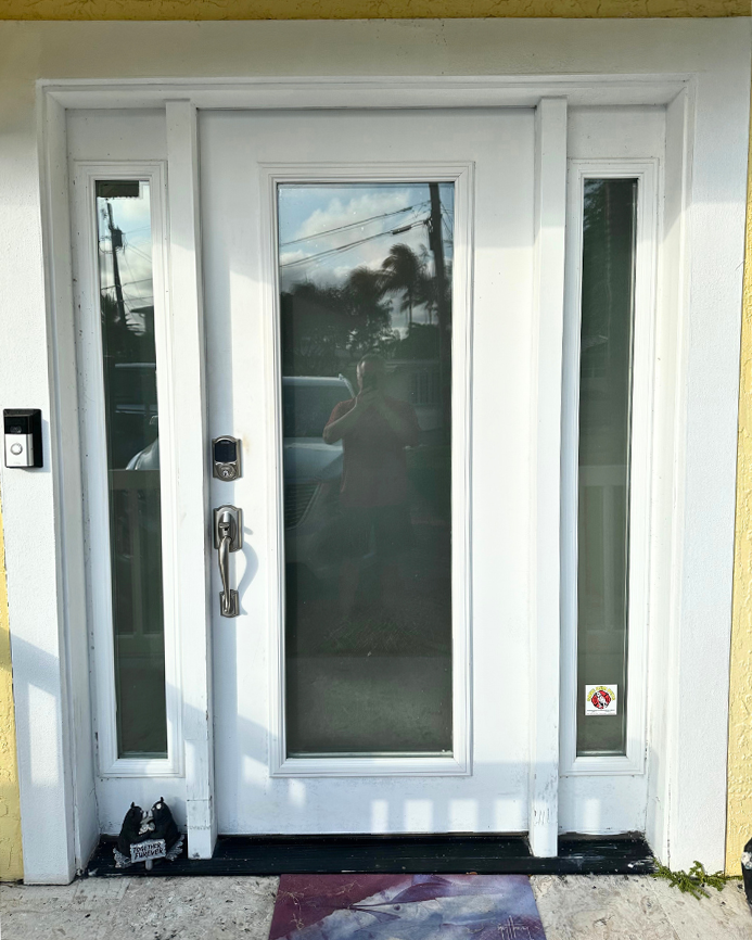 A white door with a reflection of a car in it