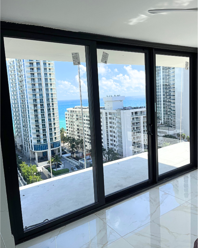 A large window with a view of a city and the ocean