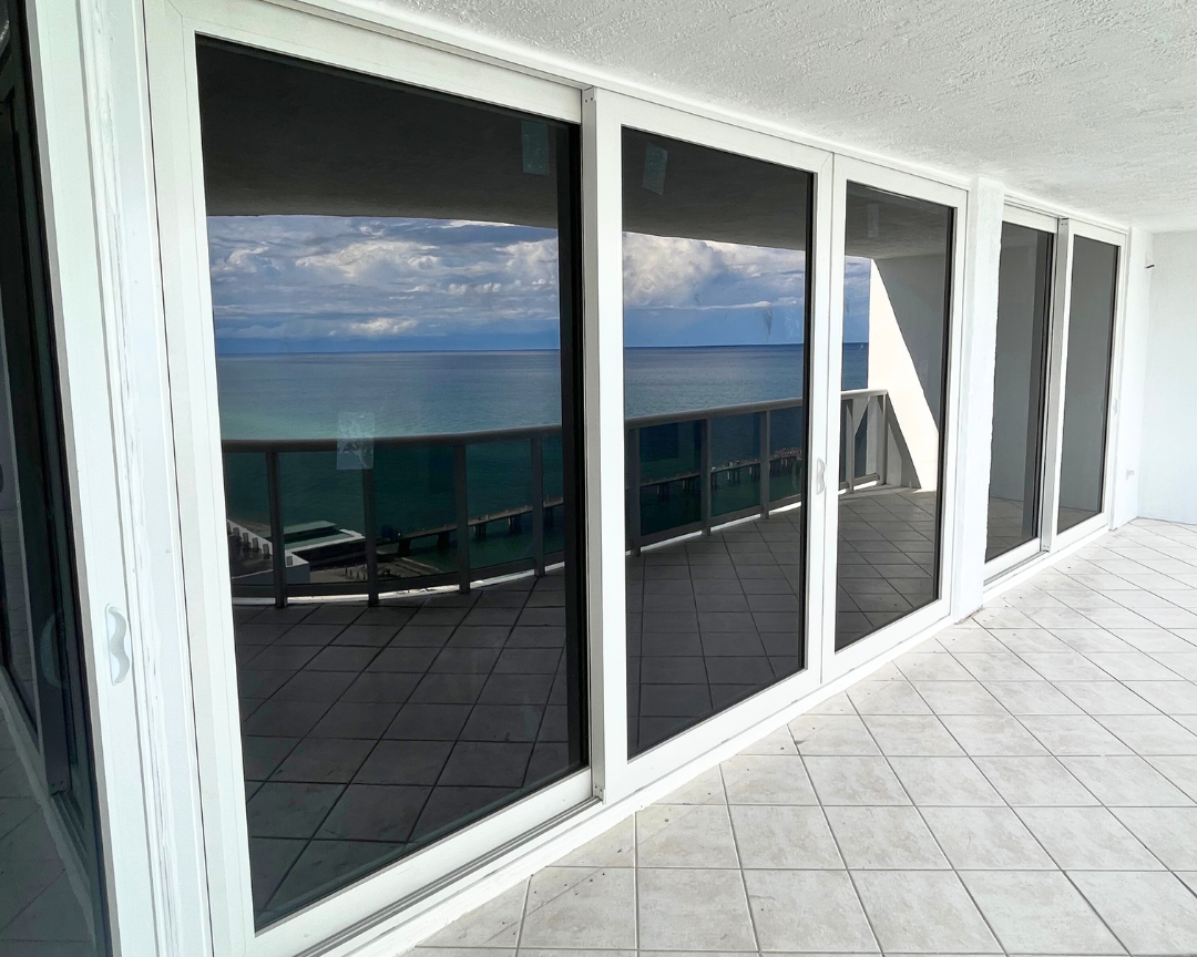 A balcony with sliding glass doors overlooking the ocean