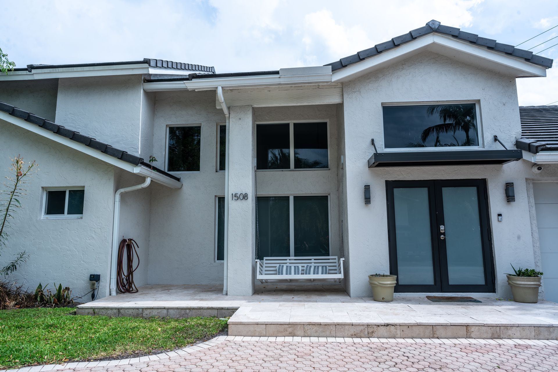 A large white house with a swing in front of it