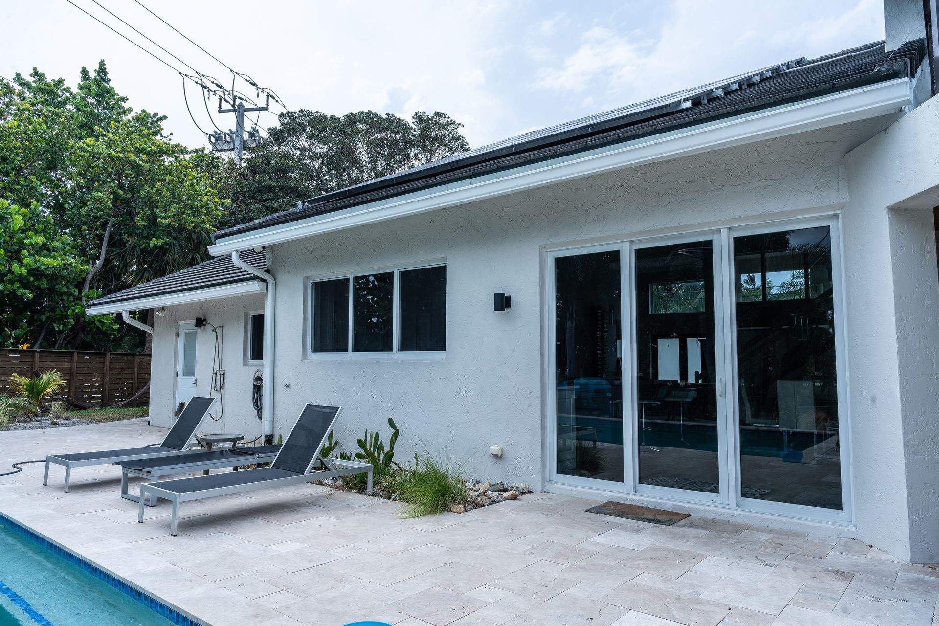 A white house with a swimming pool in front of it