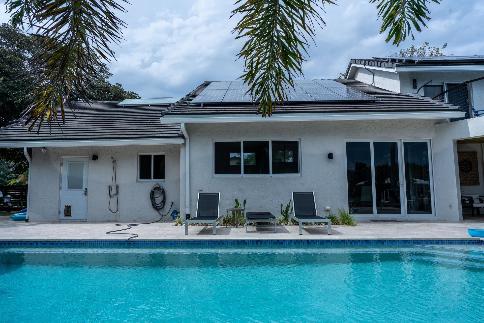 A white house with a swimming pool in front of it