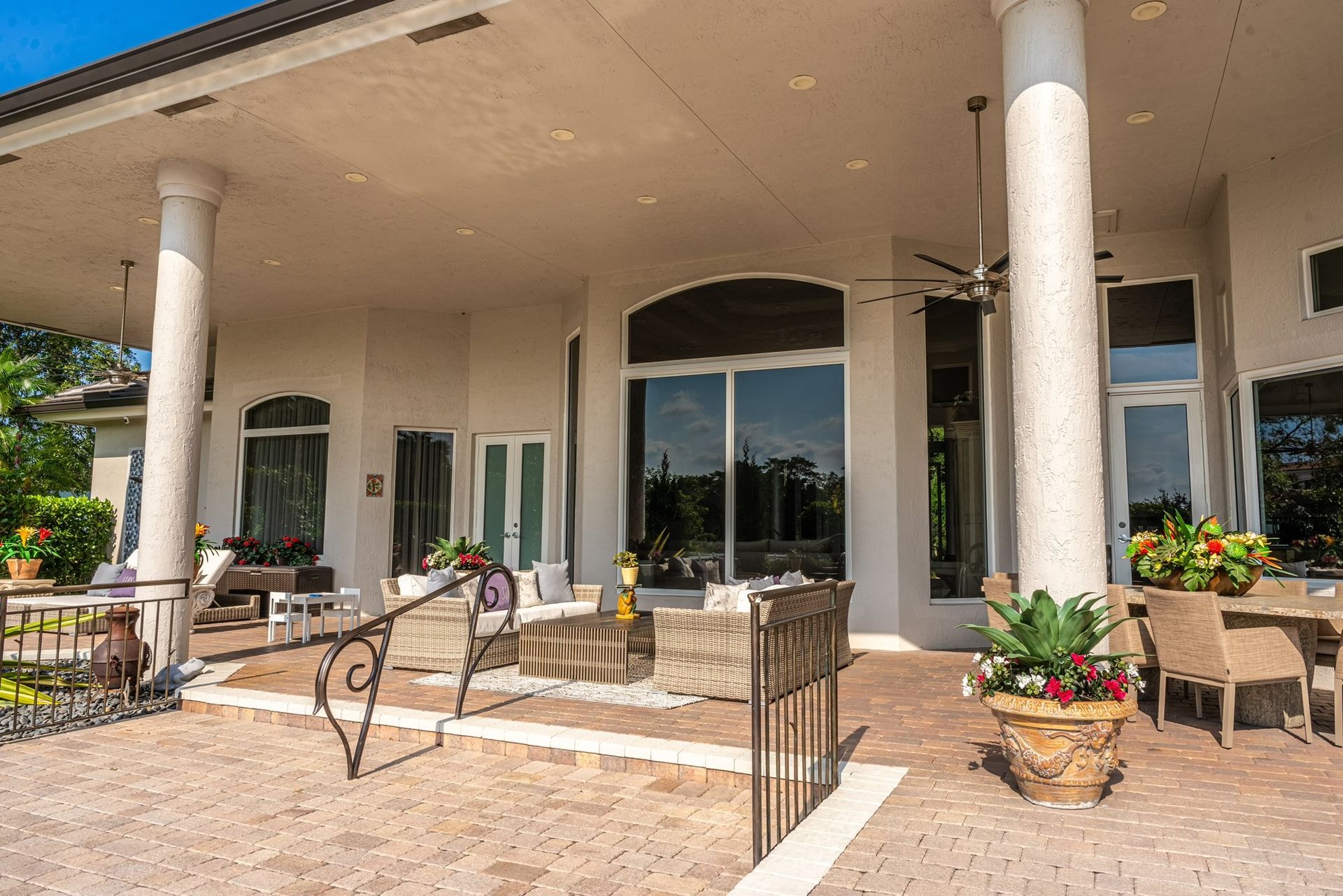 A large white house with a patio area and a ceiling fan.