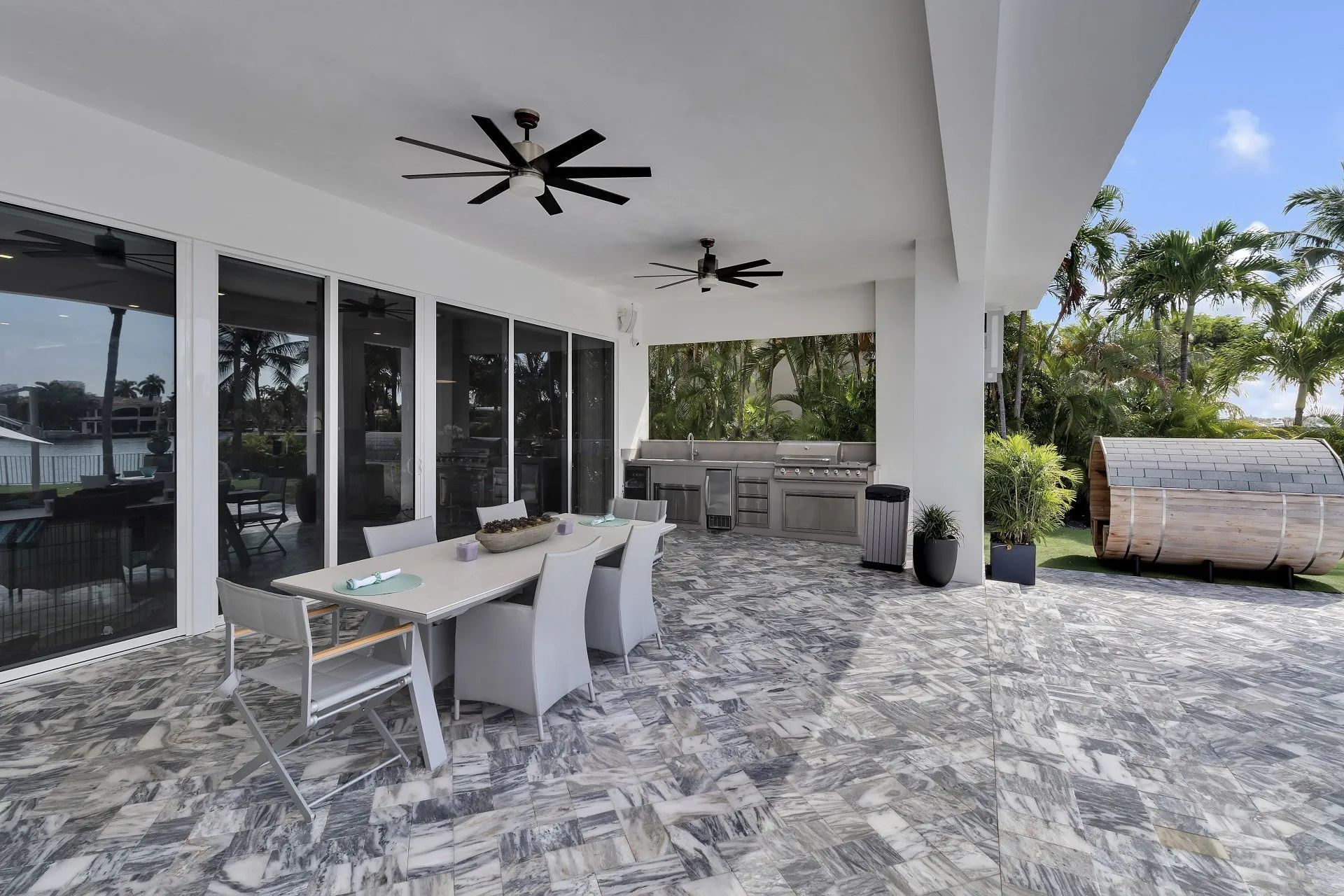 A large patio with a table and chairs and a grill.
