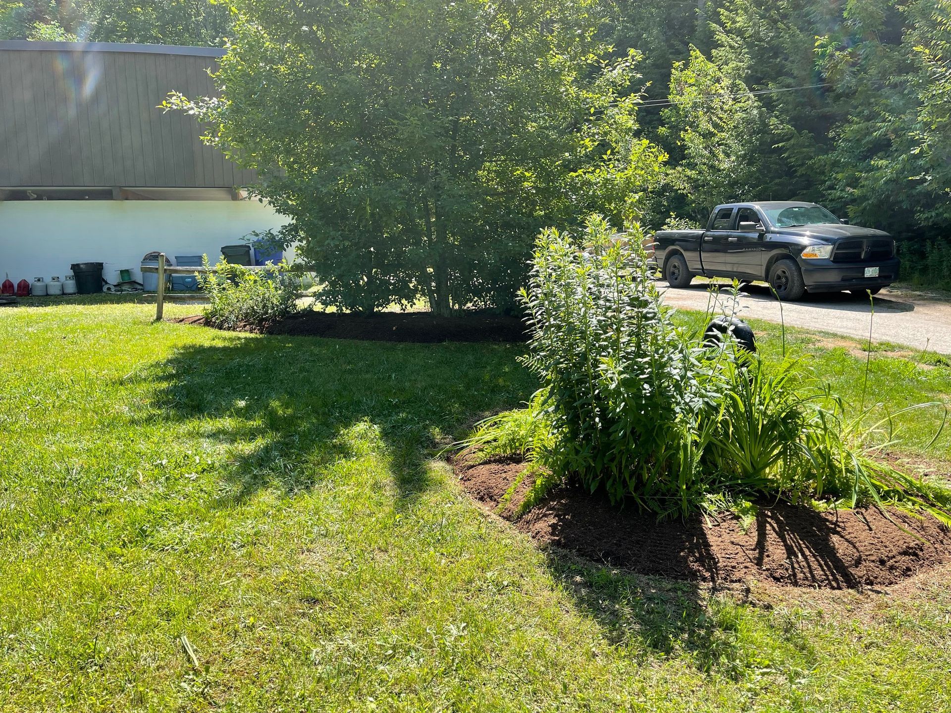 A truck is parked in the grass in front of a house.