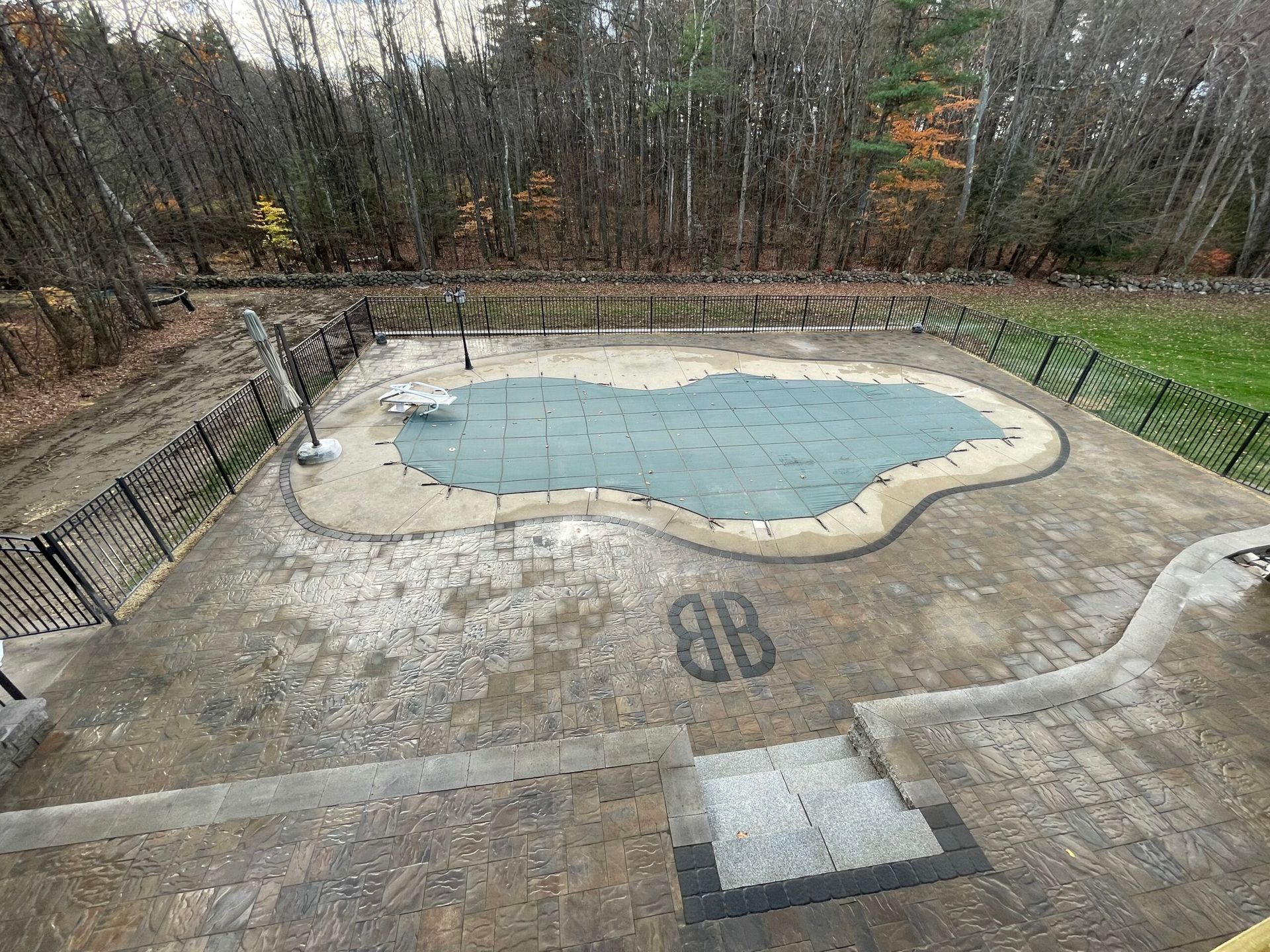 An aerial view of a large swimming pool surrounded by trees.