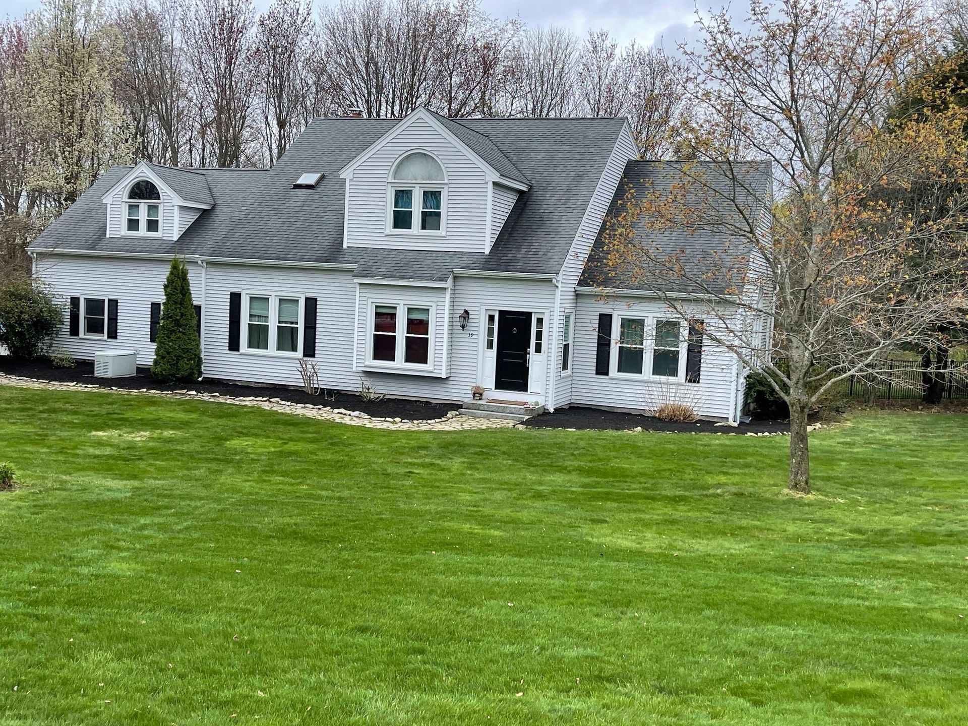 A large white house with a lush green lawn in front of it.