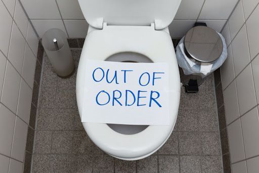 A toilet with a piece of paper on it that says out of order.