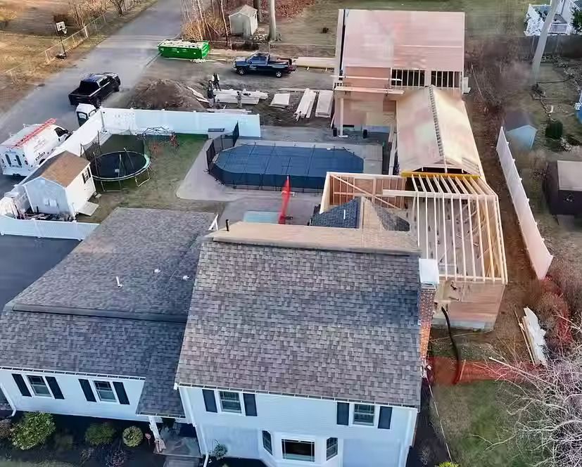 An aerial view of a house under construction with a pool in the backyard.