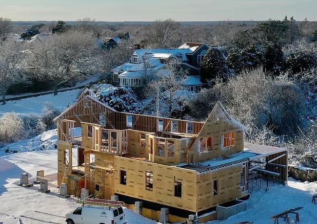 An aerial view of a house under construction in the snow