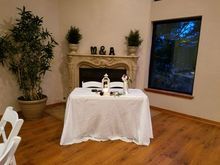 Wedding reception table set for two, under a fireplace with 