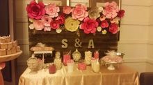Dessert table decorated with paper flowers and initials, 