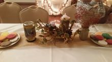 Table setting with cookies, candle, and floral arrangement.