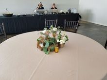 Round table with floral centerpiece, buffet in background.