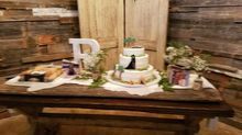 Wedding cake on rustic wooden table, with floral arrangements and decorations.