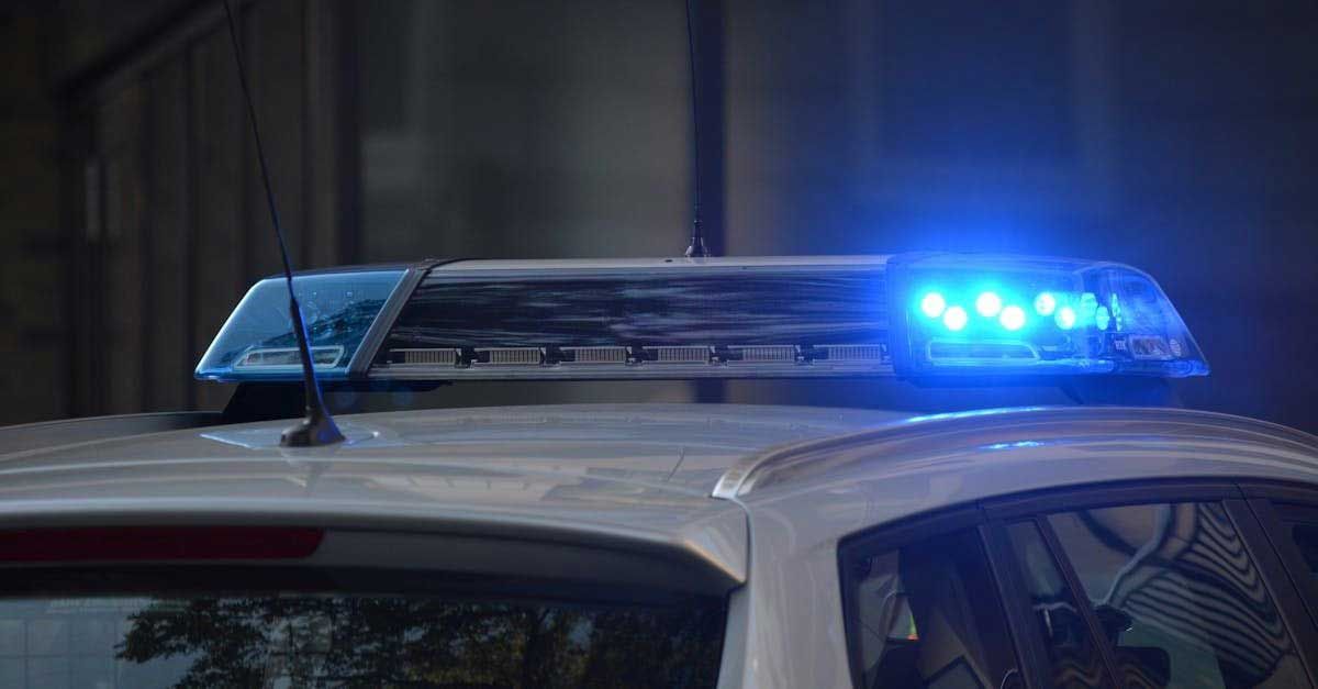 Police car roof with flashing blue lights at night