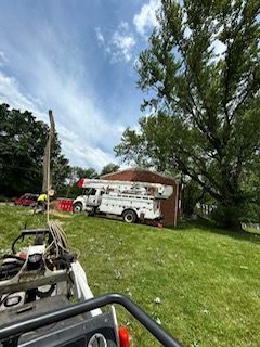 A white truck is parked in the grass in front of a house.