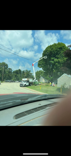 A car is driving down a street with a crane in the background.