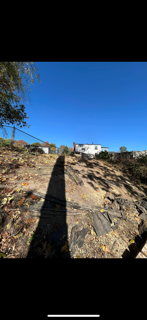 A person 's shadow is cast on a rocky hillside.