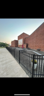 A brick building with a fence around it and a fire hydrant in front of it.
