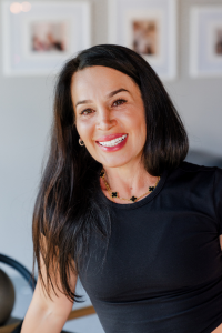 A woman in a black shirt is smiling for the camera.