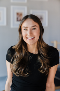 A woman in a black shirt is smiling for the camera.