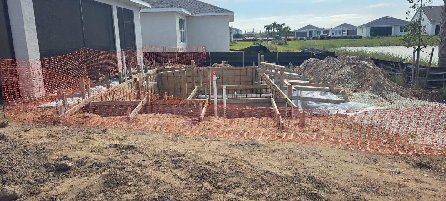 A large pile of dirt is sitting in front of a house under construction.