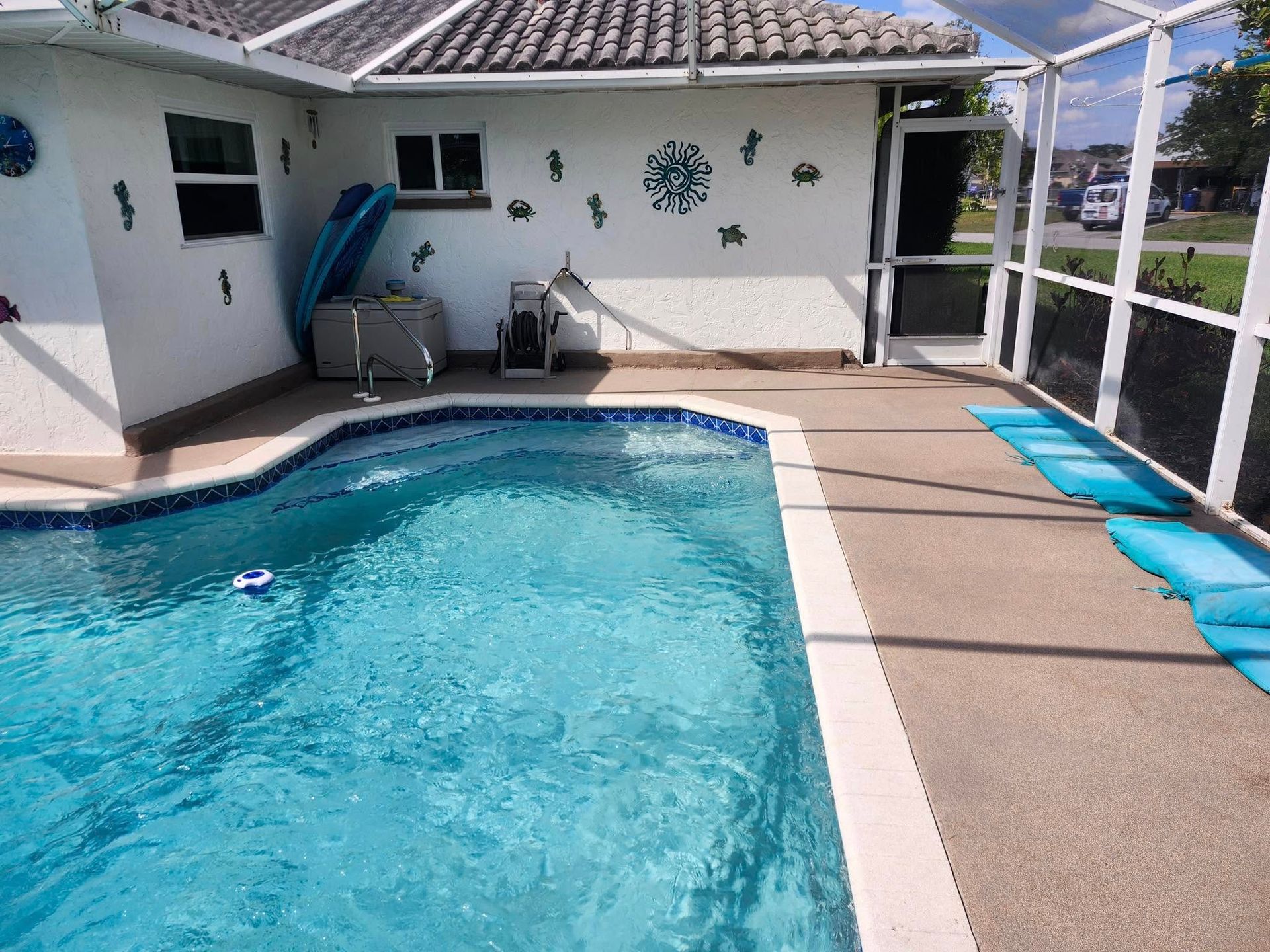 A large swimming pool in front of a white house