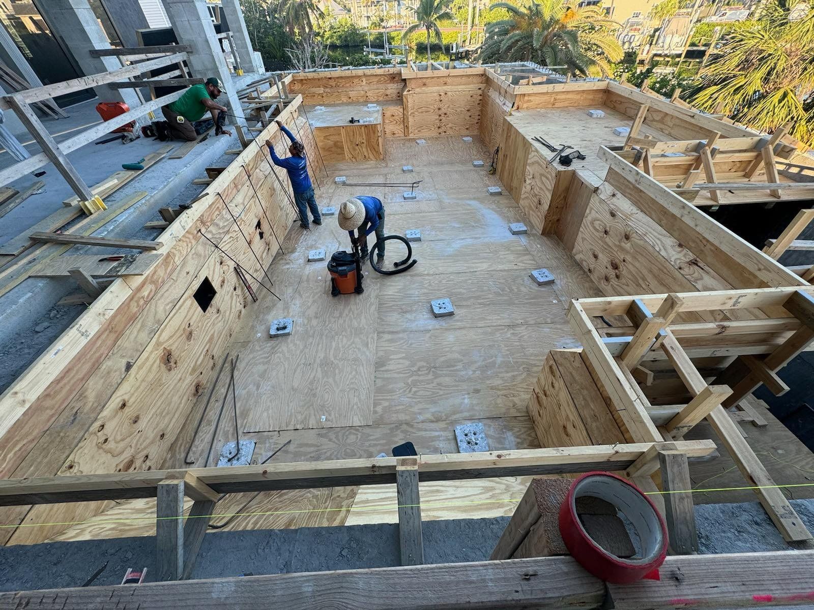 A large wooden swimming pool is being built on top of a wooden deck.