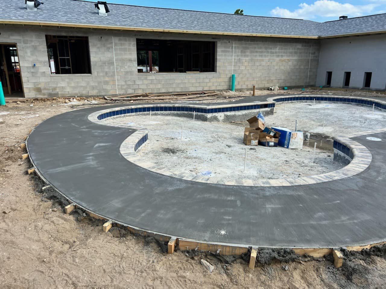 A swimming pool is being built in front of a house.