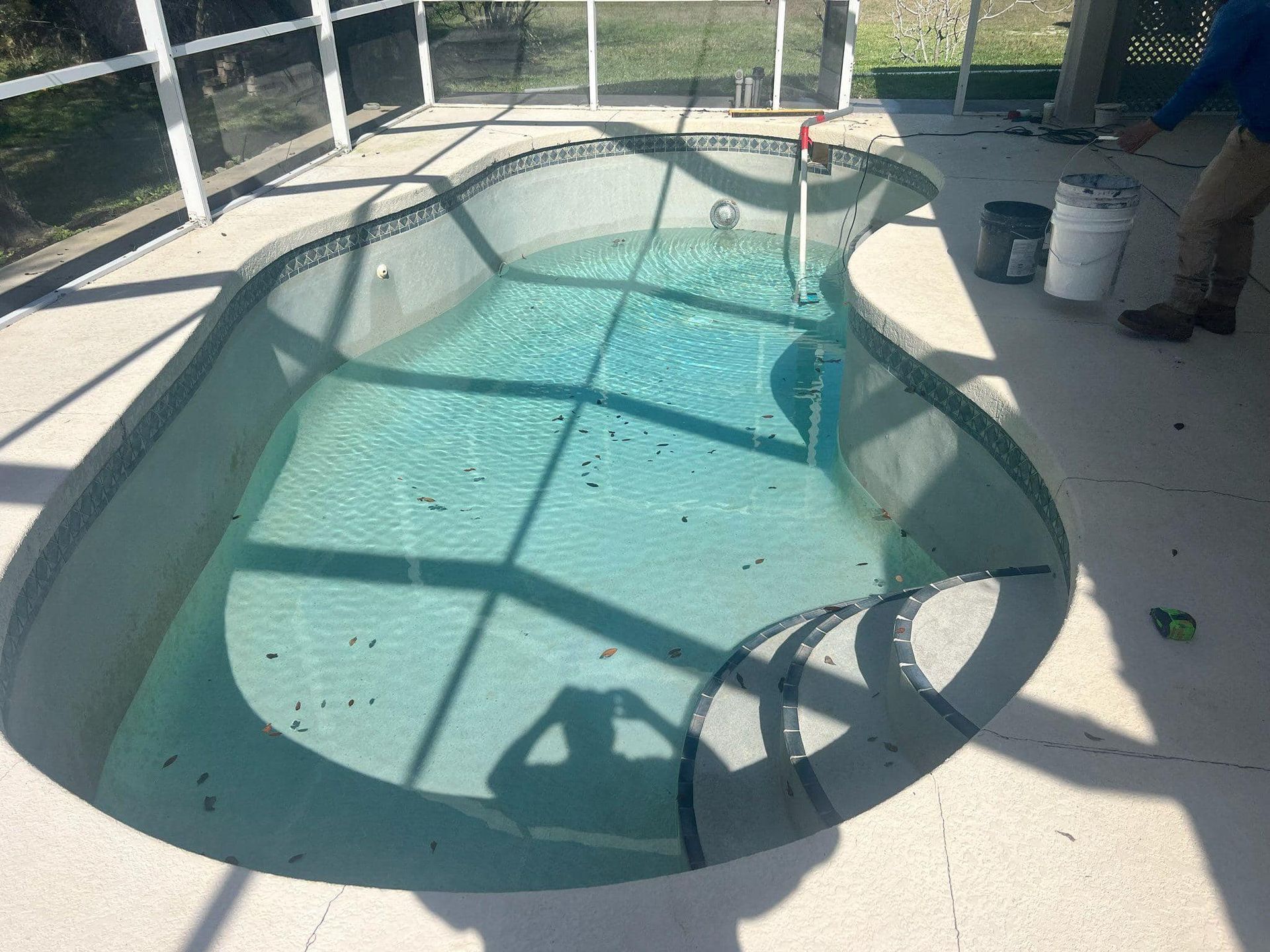 A man is standing in front of a swimming pool.
